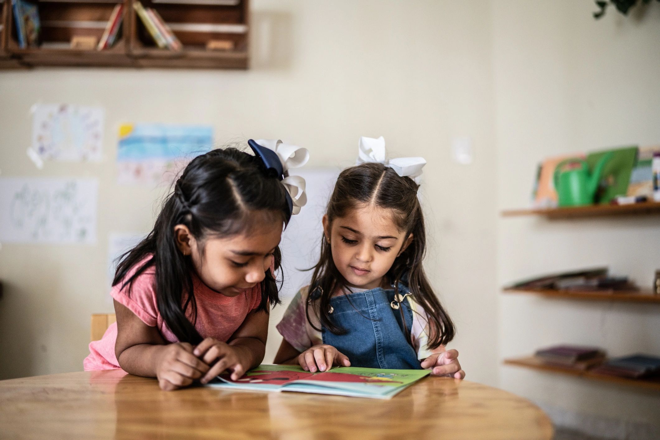 Children reading a book together in a classroom